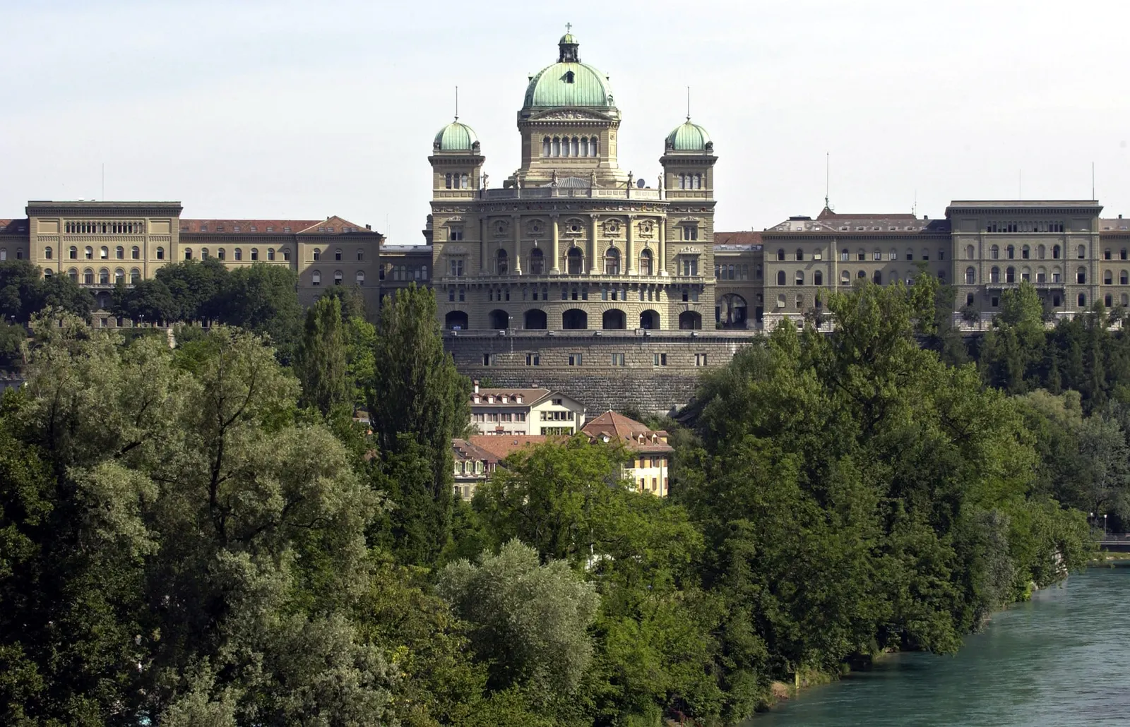 Das Bundeshaus in Bern von Süden, über den Bäumen am Aareufer