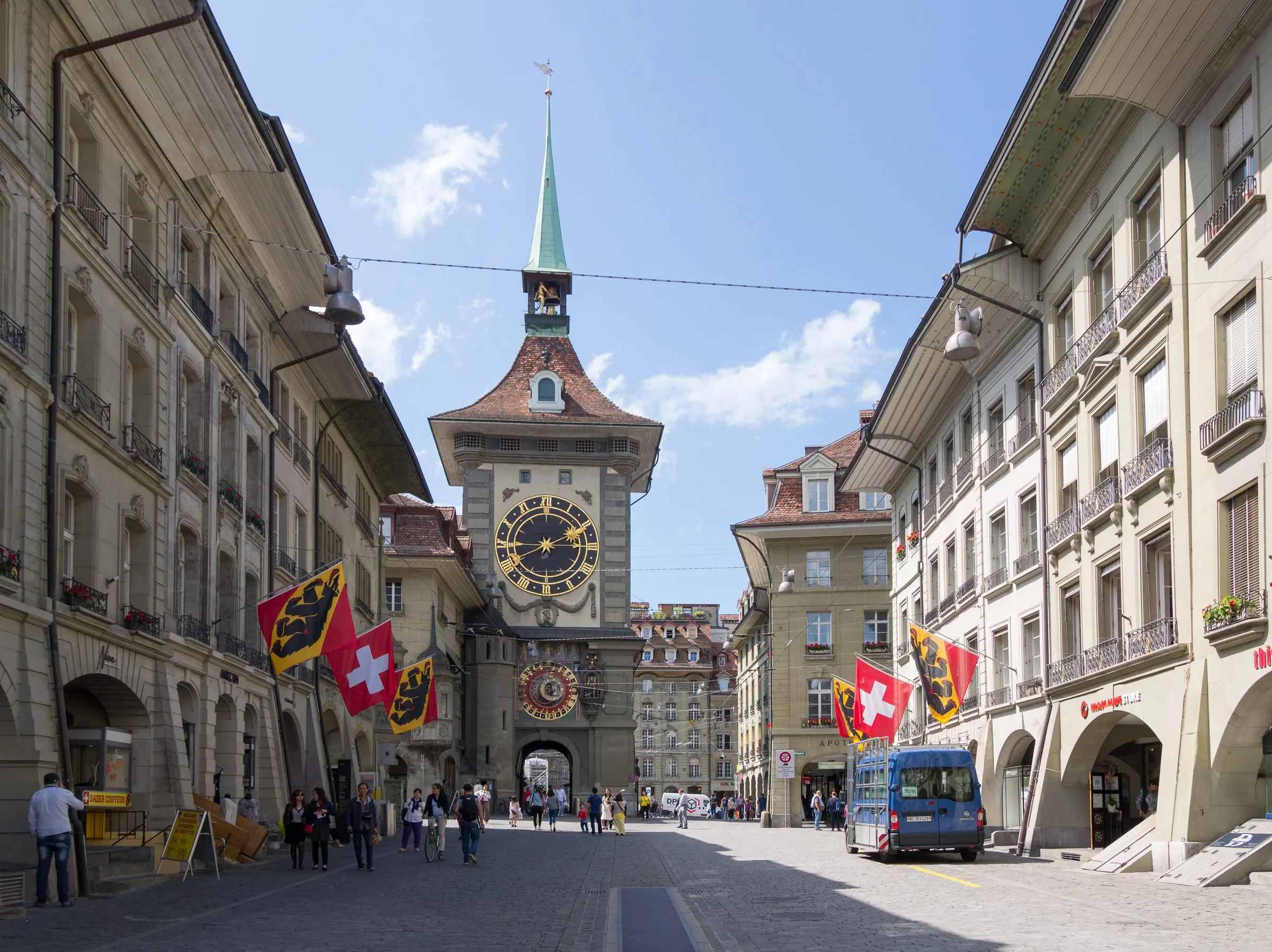Die Kramgasse in Bern mit dem Zytglogge-Turm, Berner und Schweizer Fahnen und Passanten